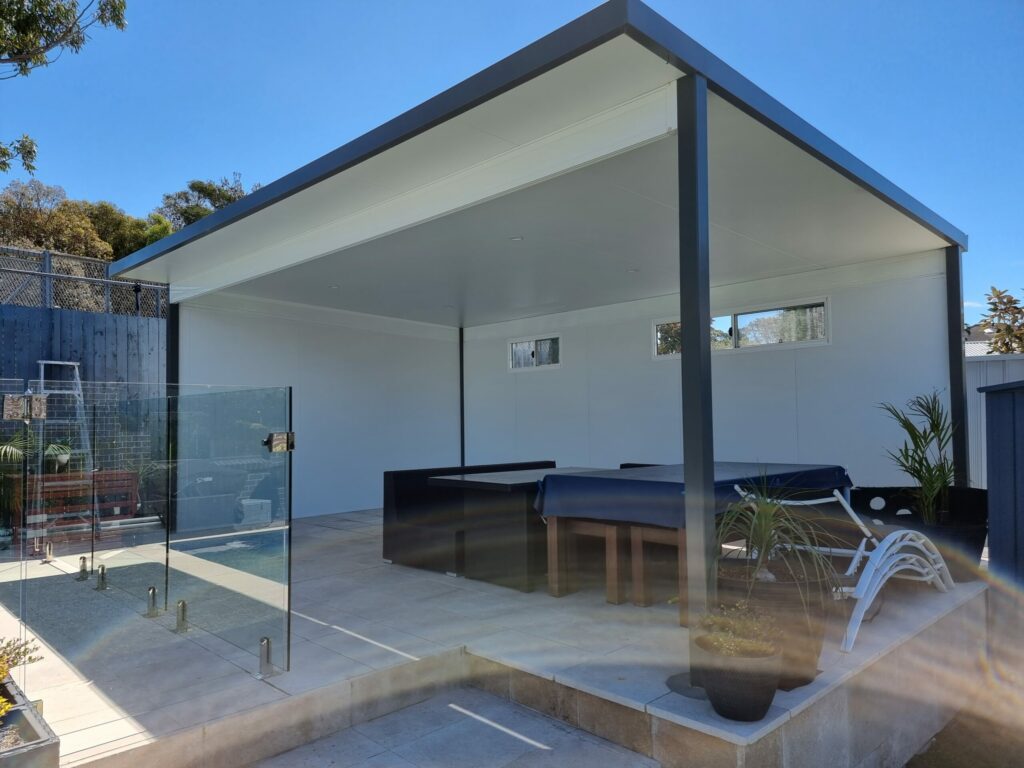 Modern outdoor patio with glass fence and tables.