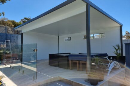 Modern outdoor patio with glass fence and tables.