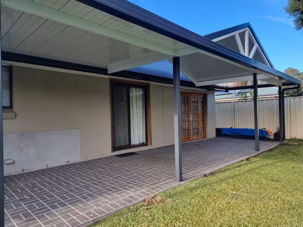 Covered patio with tiled floor and garden view.
