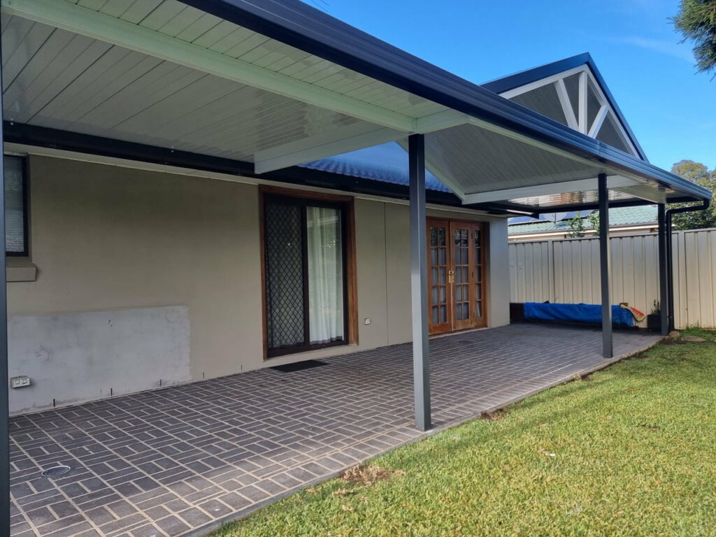 Covered patio with tiled floor and garden view.