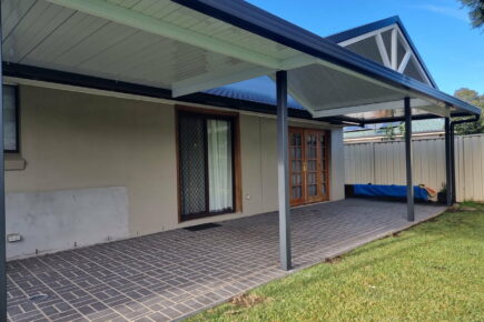 Covered patio with tiled floor and garden view.