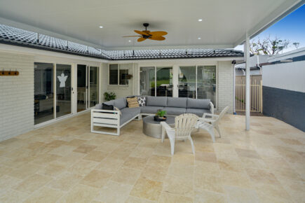 Modern outdoor patio with seating area and fan.