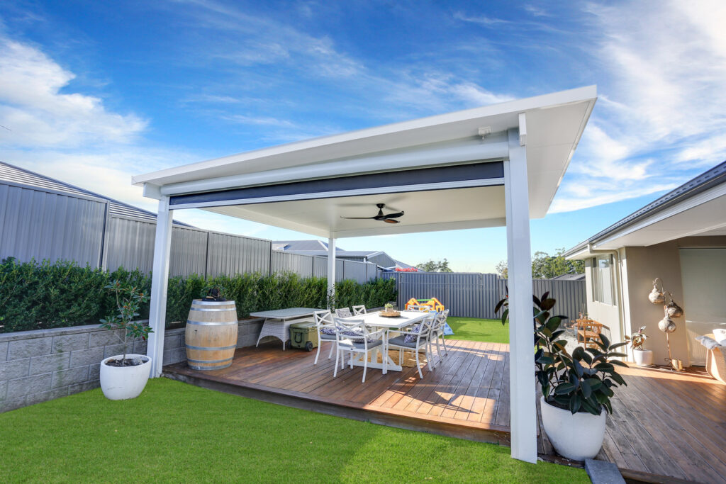 Modern outdoor patio with dining area and greenery.