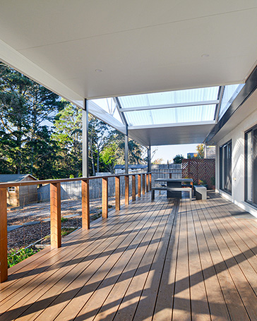 Spacious outdoor deck with wooden flooring and railing.