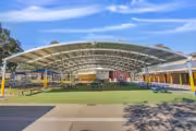 Outdoor school cola with seating and shade canopy.