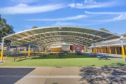 Outdoor school cola with seating and shade canopy.