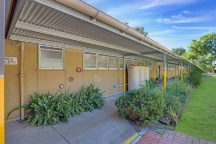 School walkway with garden and water tanks.