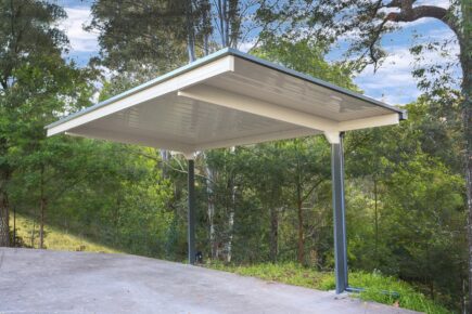 Modern outdoor shelter amidst lush green trees.