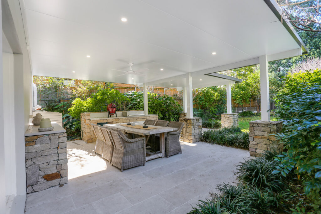 Modern outdoor patio with garden and dining area.