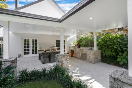 Modern outdoor patio with dining area and garden view.